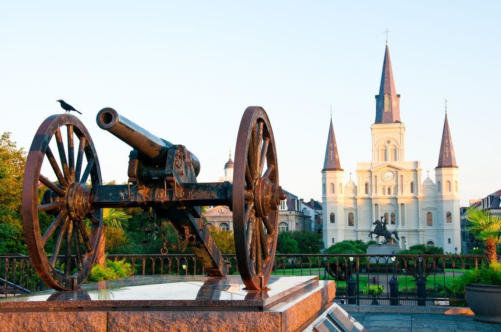 Jackson Square with a historic cannon in the foreground, embodying New Orleans' rich heritage, set against the backdrop of the iconic St. Louis Cathedral.