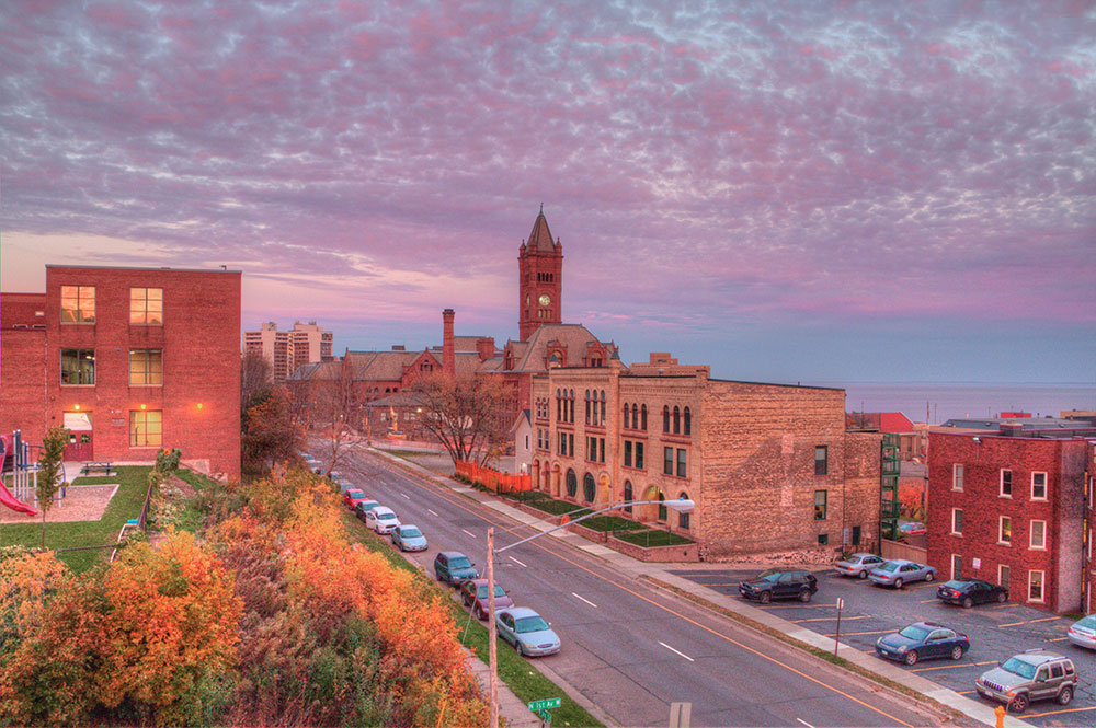 Panoramic view of downtown Duluth, MN, against the expansive backdrop of Lake Superior during the golden hour.