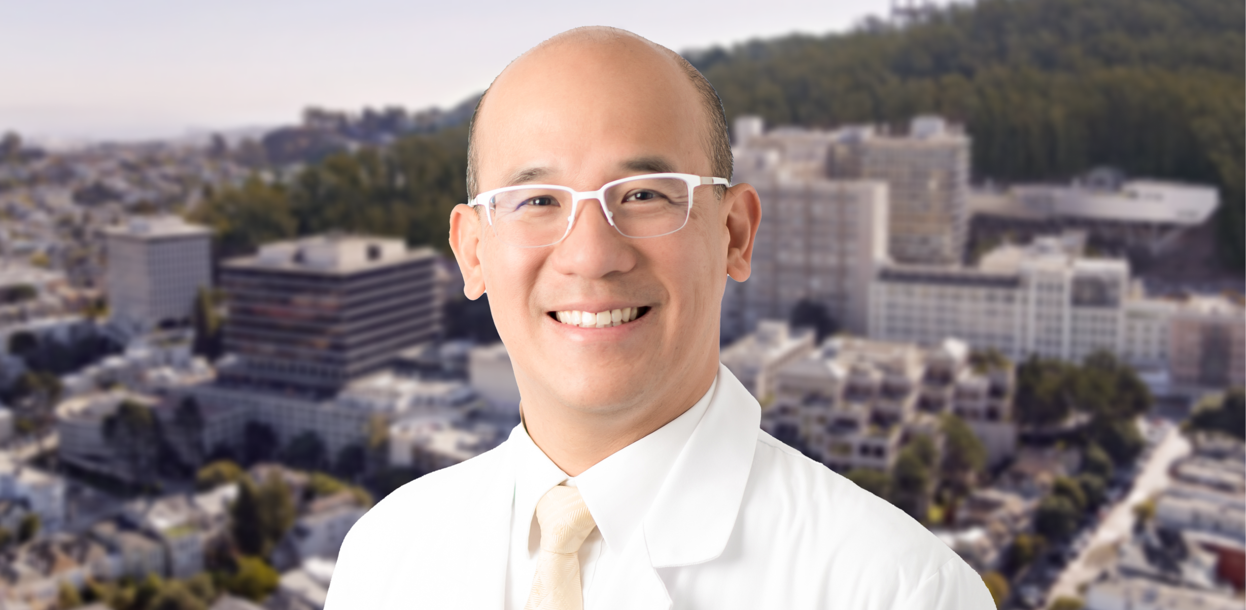 Dr. C. Benjamin Ma in his white coat and tie, wearing white glasses, with the UCSF hospital campus backdrop.